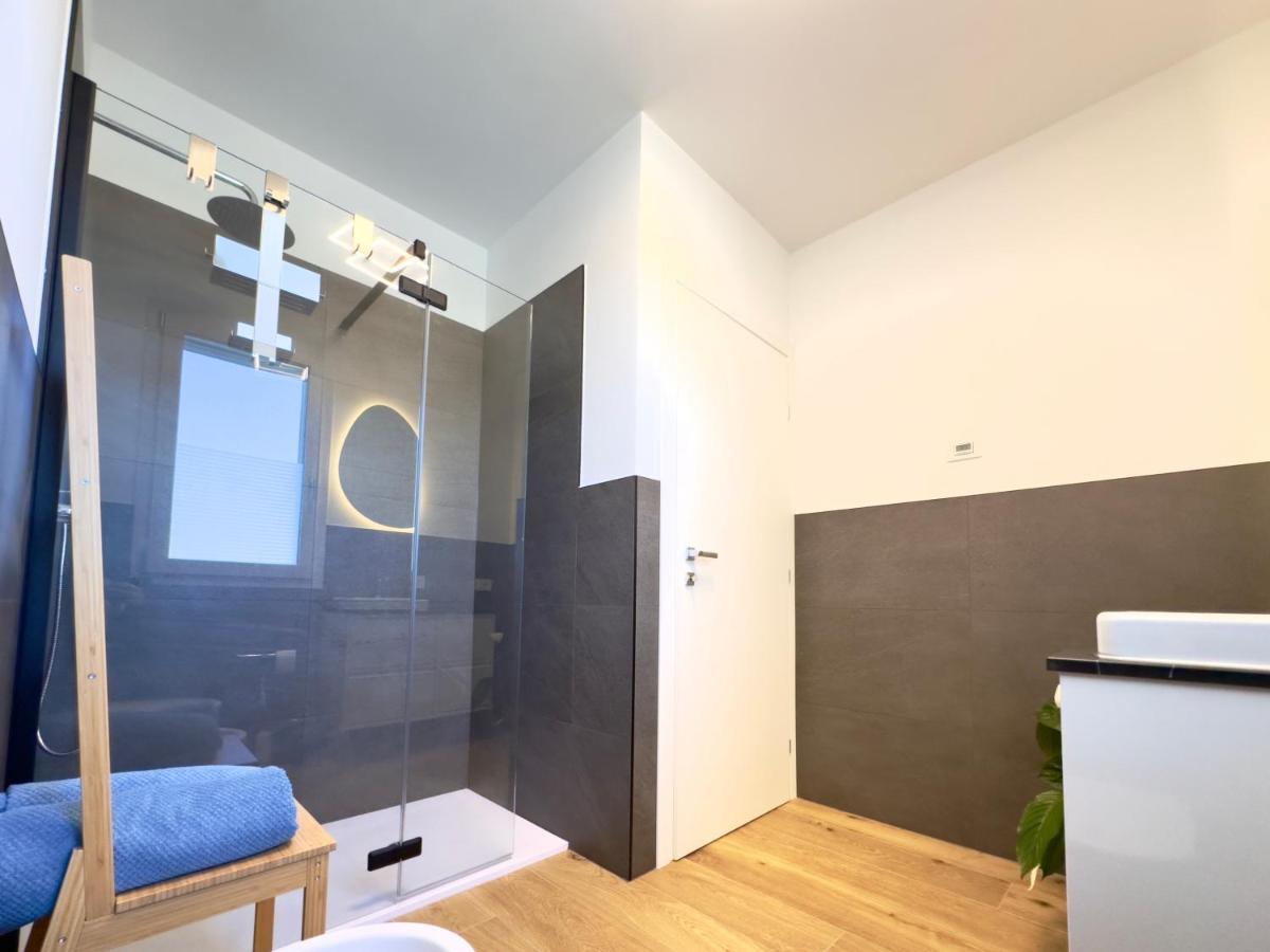Bagno con doccia walk-in e specchio rotondo illuminato