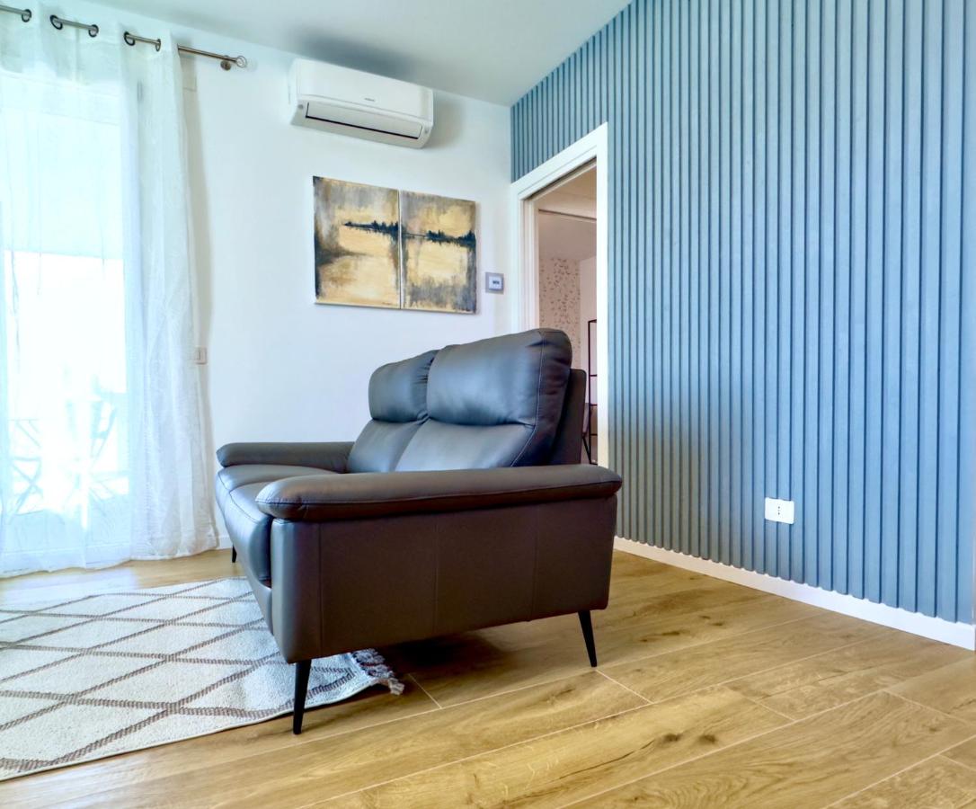 Soggiorno con divano in pelle nera e parete blu